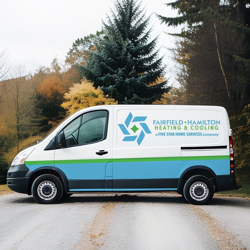 Company service van parked on a tree-lined road